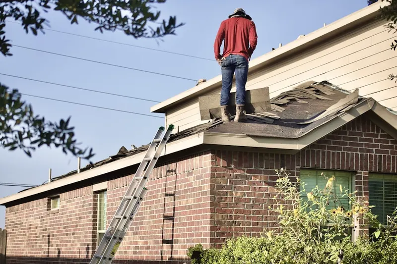 Professional roofer working on a residential roof in Inman